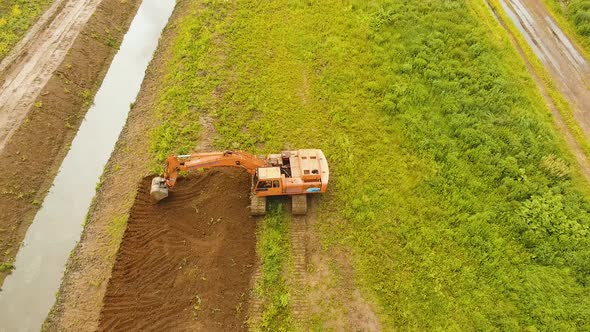 Excavator Digging a Trench in the Field