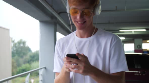 Stylish Redhead Man With Phone Listening Music In Headphone