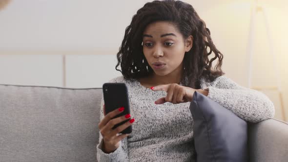 Young African American Lady Video Calling to Friends Talking Via Smartphone App Feeling Shocked From