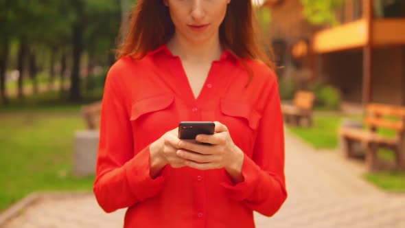 Businesswoman Typing Message Walking in Park Slow Motion