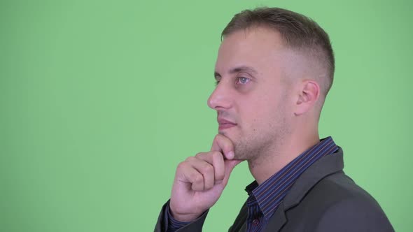 Closeup Profile View of Happy Businessman in Suit Thinking