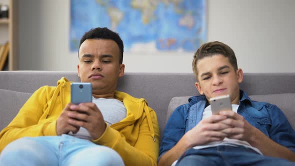 Multiracial Teenage Friends Playing Games on Smartphones, Ignoring Each Other