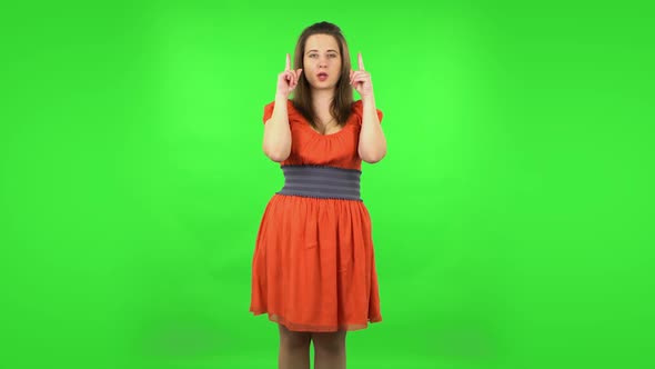 Cute Girl Pointing Fingers Up for Something with Copy Space.. Green Screen