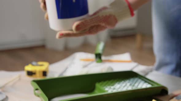 Hands in Gloves Pouring Grey Color Paint to Tray