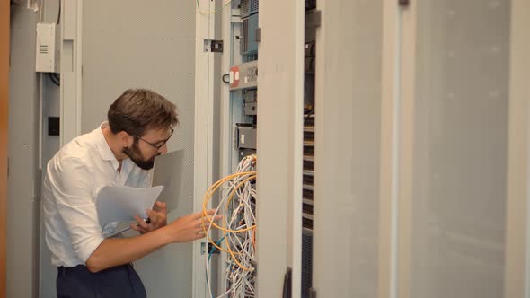 It Administrator Working In Server Room And Connecting Ethernet Wire.Web Network Hosting Server Room