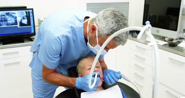 Dentist examining a young patient with tools