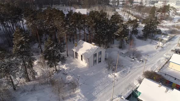 Drone shot of new white modern residential house at winter near the forest 07