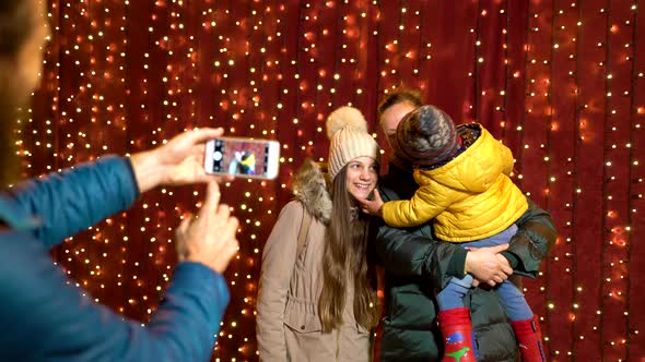 Father taking photo of family at Christmas market on the night.