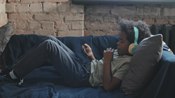 Boy Using Smartphone on Couch