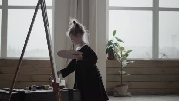 Girl painting a picture with brushes