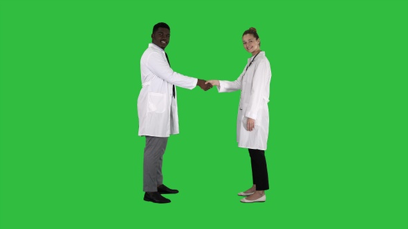 Doctors shaking hands and posing to camera on a Green Screen