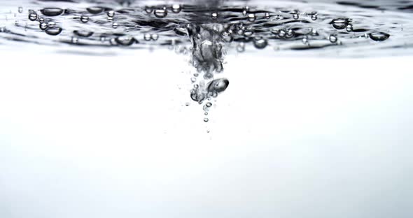 Water drips into a water surface - white background