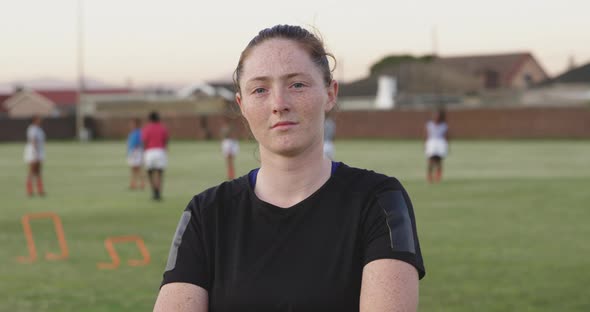 Portrait of young adult female rugby player on a rugby pitch