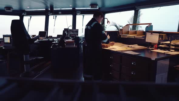 Marine Navigational Officer During Navigational Watch on Bridge . He Does Chart Correction