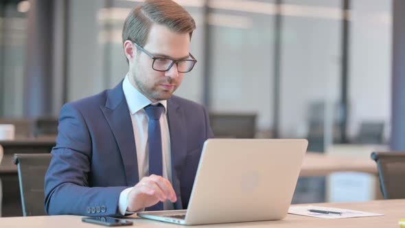 Successful Businessman Celebrating on Laptop at Work