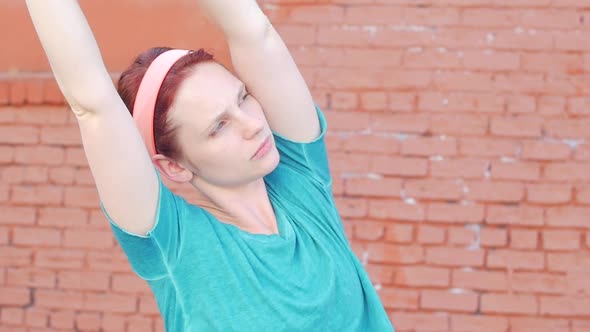 A young woman stretching before working out in urban environment.