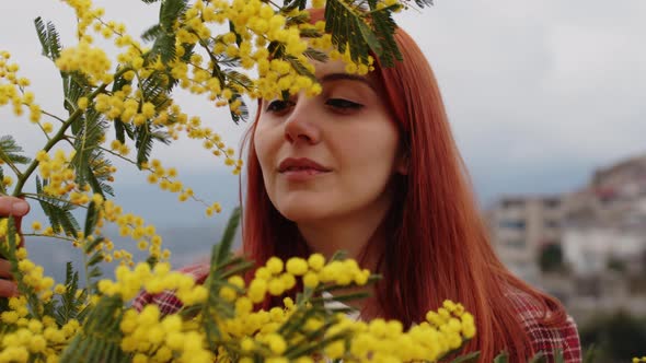 Young Girl Celebrates Women's Day with Yellow Mimosa Flowers in Hand