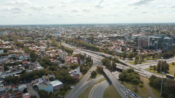 Aerial view of trees, houses and transit on General Paz avenue at Buenos Aires city