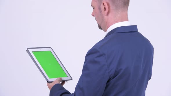 Rear View of Businessman Using Digital Tablet