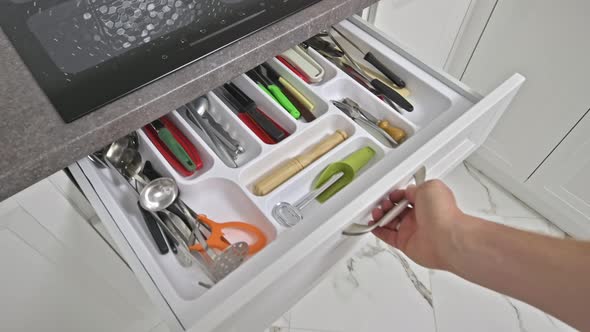 Male Hand Gentle Opens and Closes a Kitchen Drawer
