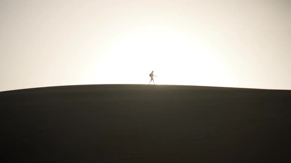 Silhouette Of Man Along Sand Dune