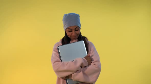 Portrait of African Girl in Cap Hugging Her Computer Laptop