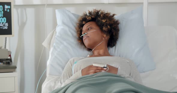 African Sad Woman Lying with Fever on Bed in Hospital Indoor