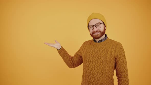 Excited Young Bearded Man Posing and Pointing Copy Space Isolated on Yellow Orange Background