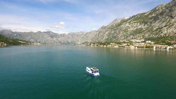 Small Fishing Boat in a Mountainous Bay Aerial Chase