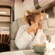 Caucasian woman making beauty skin treatment using cream and mirror sitting inside camper van - VideoHive Item for Sale