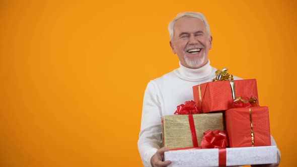 Pleased Elderly Male Holding Giftboxes and Smiling, Big Discounts on Holidays