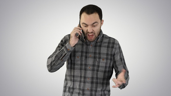 Man angry talking on telephone and walking on gradient background.