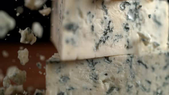 Camera follows grating blue cheese. Slow Motion.