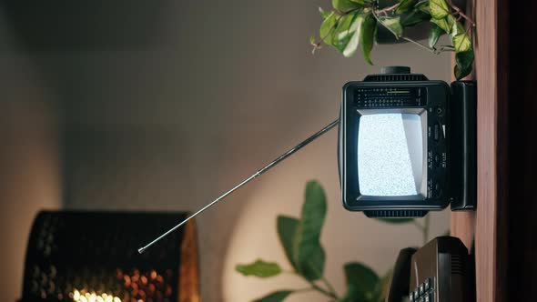 Vertical Video of Small Old Television with Grey Interference Screen on Home Background