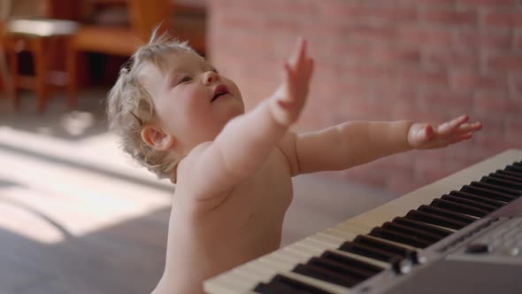 Asian Baby Girl Toddler Playing Electric Piano Sit Down on the Floor Tapping on Keyboard Music