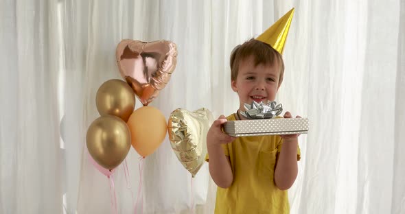 Funny Kid in Yellow T-shirt Holds Paper Present Box Closeup