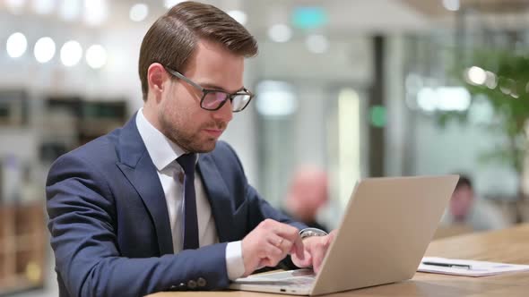 Businessman with Laptop Looking at the Camera