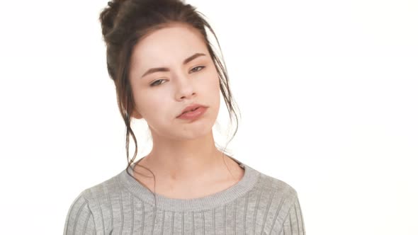 Tired Upset Caucasian Brunette Girl Standing on White Background and Heavily Sighing