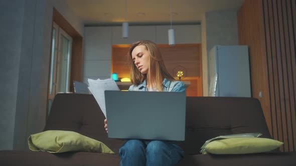 A Beautiful Woman Is Working at the Notebook at Home