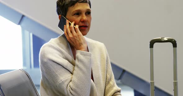 Woman talking on mobile phone in waiting area