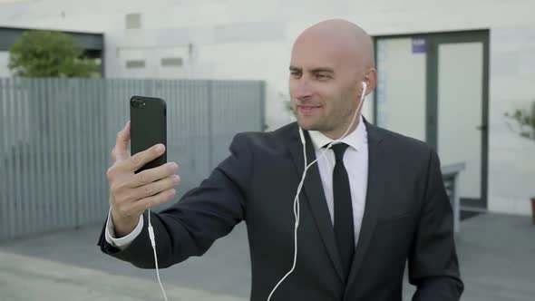 Content Bald Businessman Having Video Chat Via Smartphone