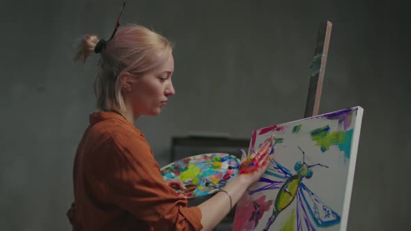Inspired Artist Creating Fingerpaint on Canvas in Art Studio