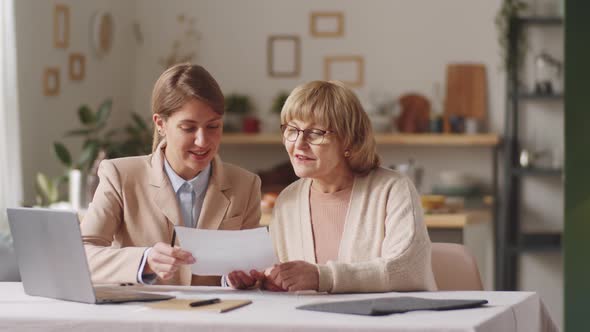 Portrait of Positive Elderly Woman and Female Financial Agent