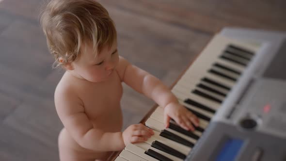 Asian Baby Girl Toddler Playing Electric Piano Sit Down on the Floor Tapping on Keyboard Music