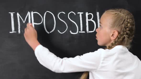 Girl Correcting Word Impossible to Possible Written on Blackboard, Motivation