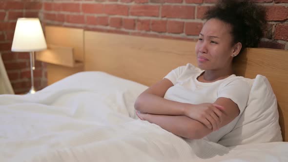 Sad African Woman Crying While Sitting in Bed