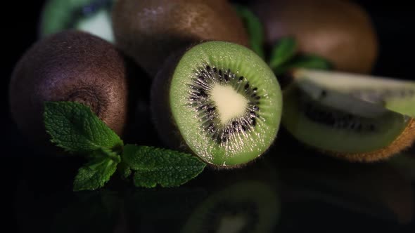 Fruits of Juicy Kiwi Rotate on a Table on a Black Background