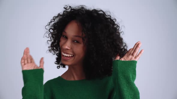 Happy curly-haired woman opening eyes at the camera