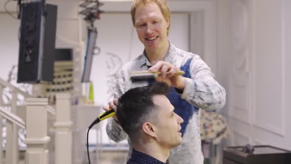 Hairdresser Dries Hair Dryer Brunette Man in a Barbershop