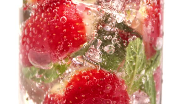 Cold Summer Strawberry Mint Ice Cocktail in Transparent Glass Wet Drops Turn Up Macro Closeup